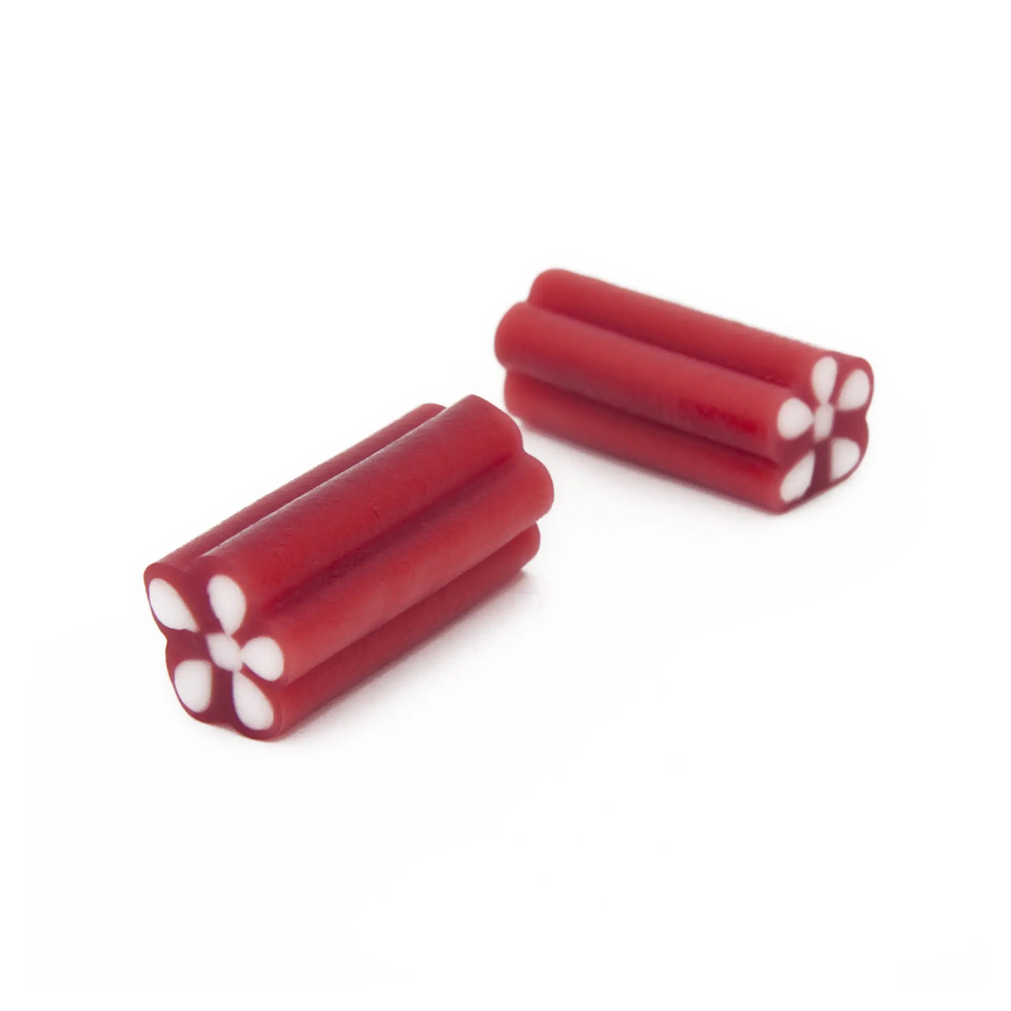 Two pieces of Swedish candy in red and white in the shape of ammo.